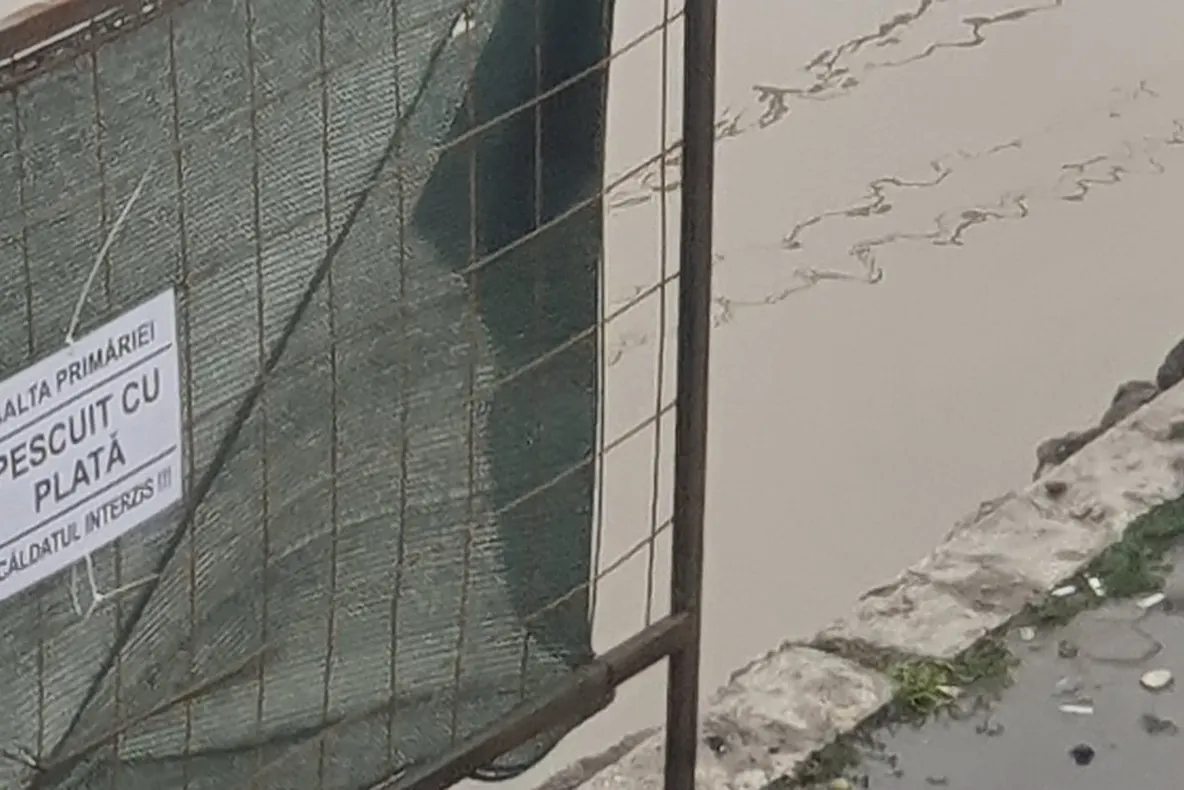 FOTO   Focșănenii au umor. Invitație la pescuit în balta formată pe șantierul din fața Școlii ”Duiliu Zamfirescu”
